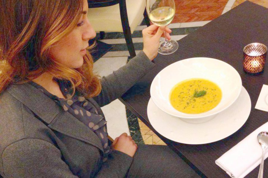 A guest with a glass of white wine at Café Montecitorio, Rome